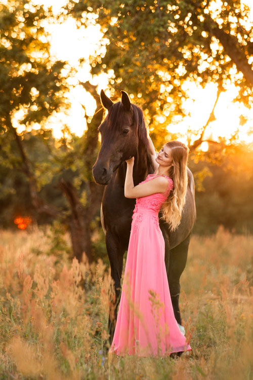 Harmonie zwischen Pferd und Frau im Sonnenuntergang